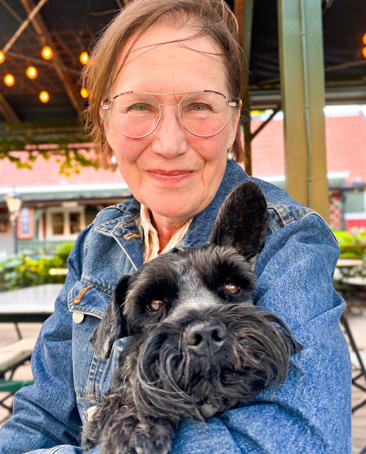 Annika med hunden i famnen vid ett uteställe